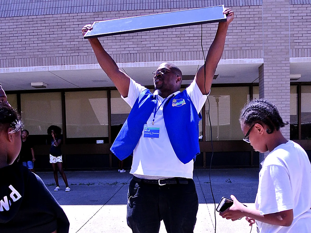 GoSolar! Kidz founder demonstrating a solar panel outdoors